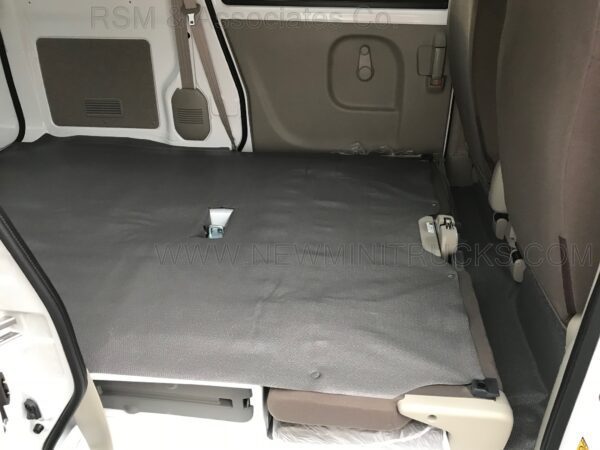 A car with the seat folded down and a cup on the floor.