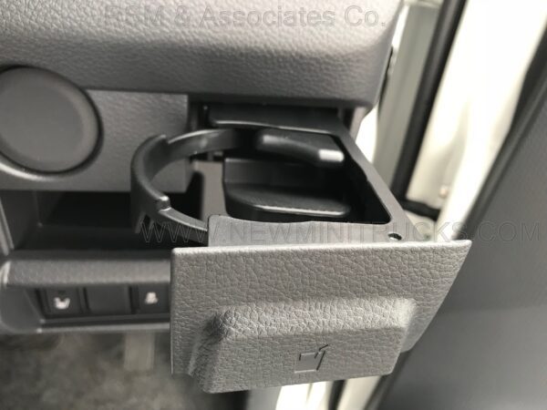 A car cup holder with the lid open.