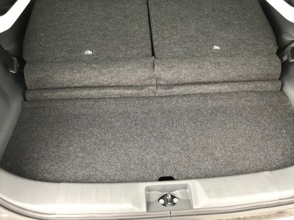 A car trunk with the back seat open.