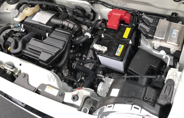 A car engine with two batteries and the hood open.