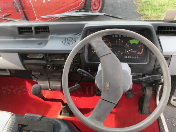 A car is shown with the dashboard and steering wheel.