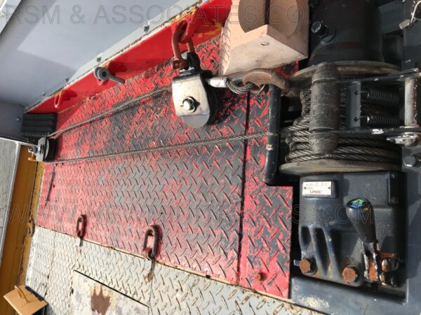 A red and black truck with a large metal diamond plate on the side.