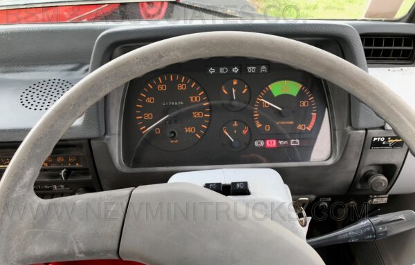 A dashboard of an old truck with the speedometer and tachometer.