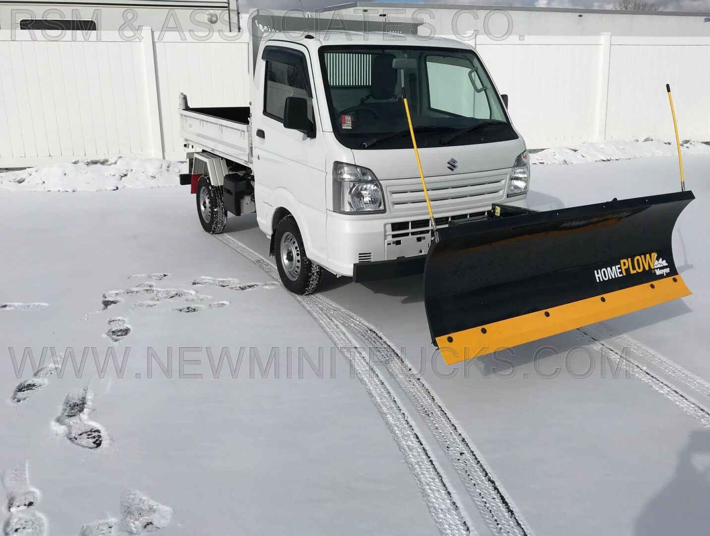 a white mini truck with a meyer home plow