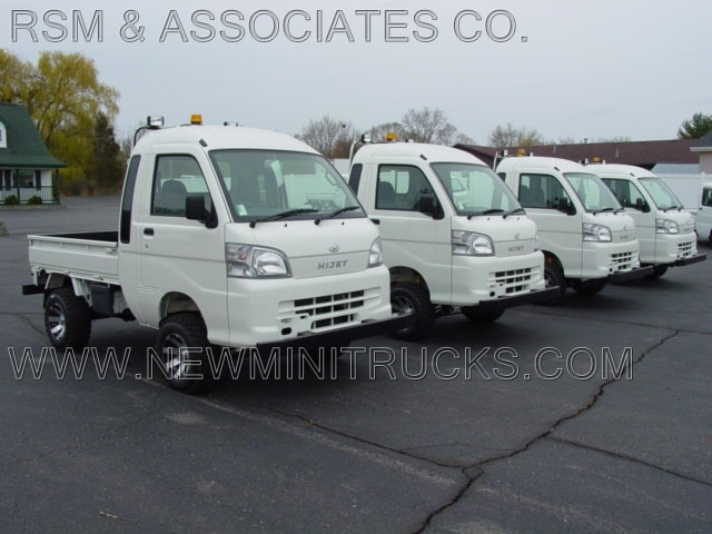 four white mini trucks in a row