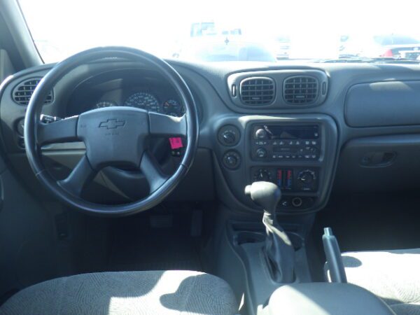 A car dashboard with the steering wheel and the center console.