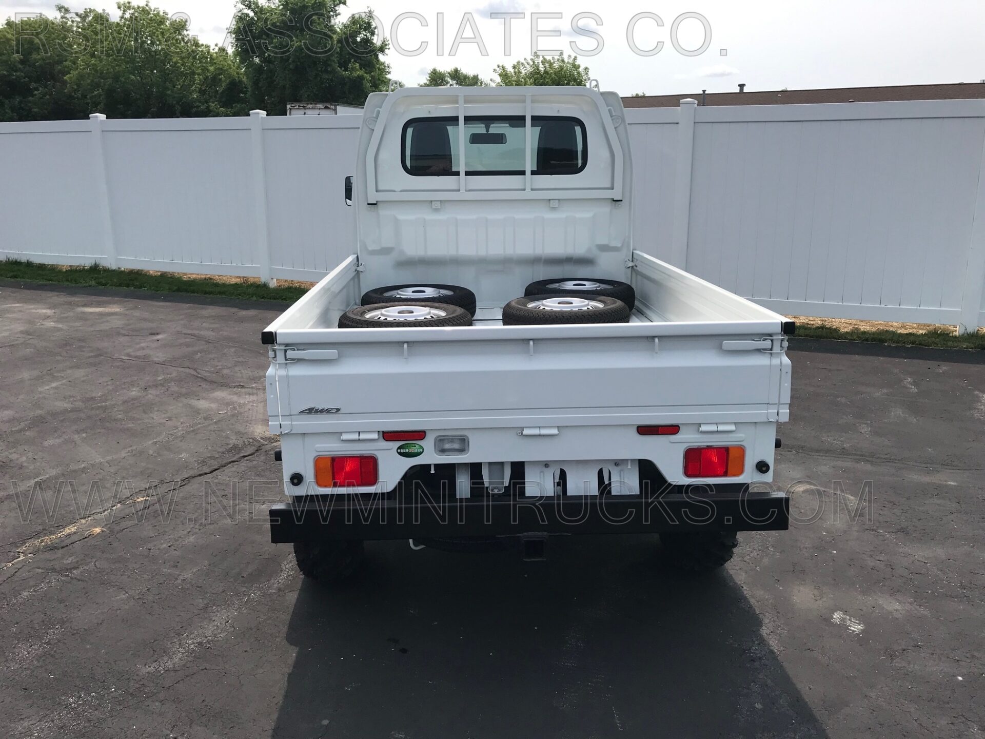 white mini truck with four extra tires