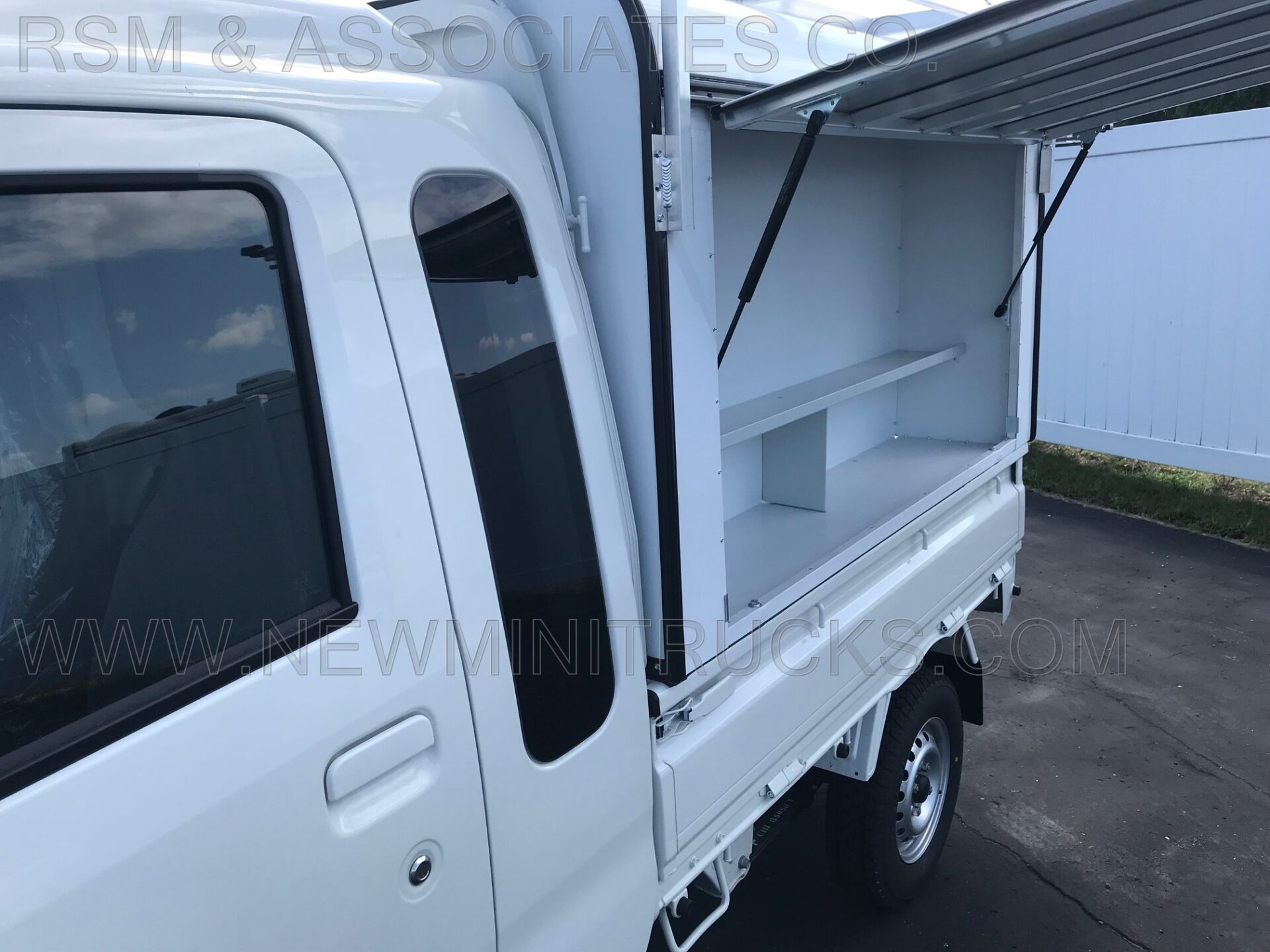 a white mini truck’s side container with a canopy
