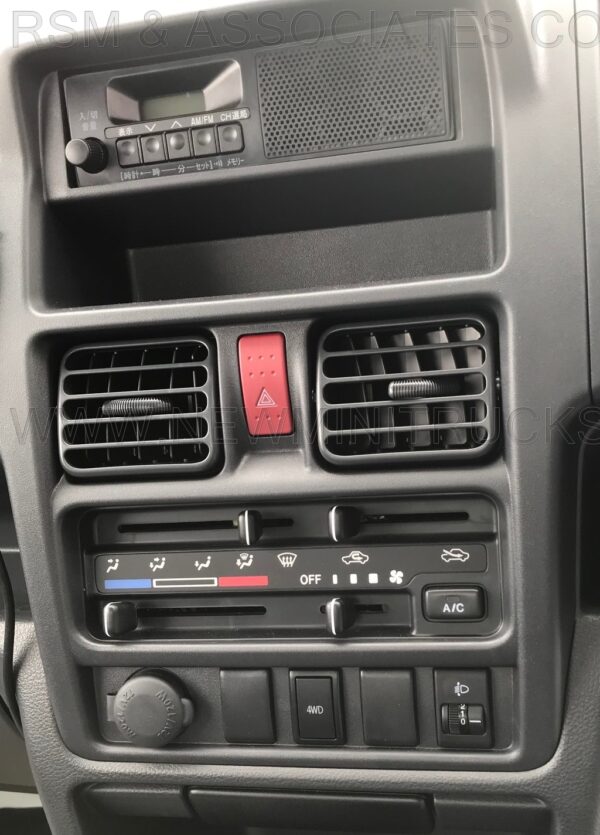 A car dashboard with air vents and buttons.